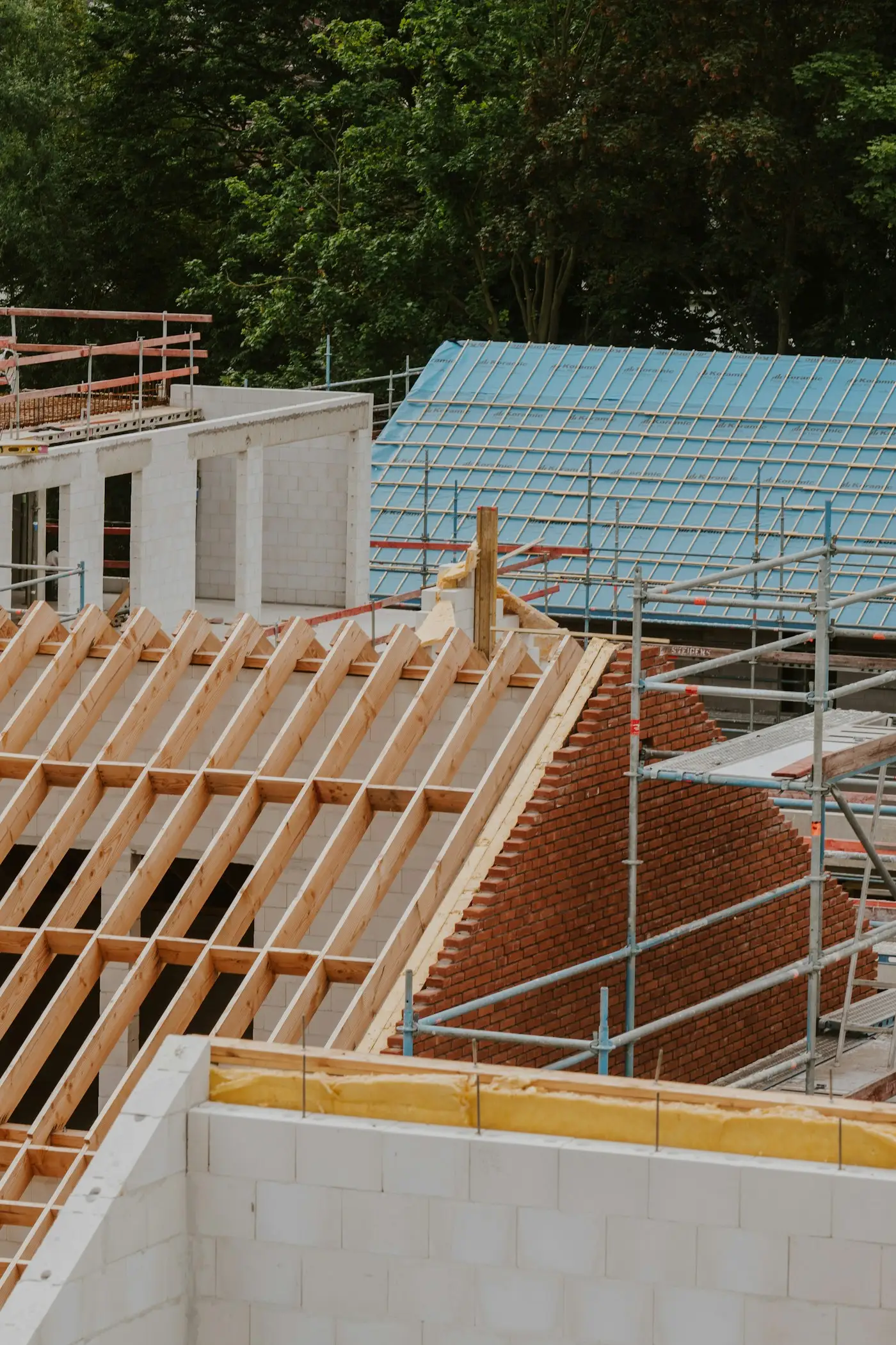 Scaffolding around new houses at roof stage, with the roof timbers going on