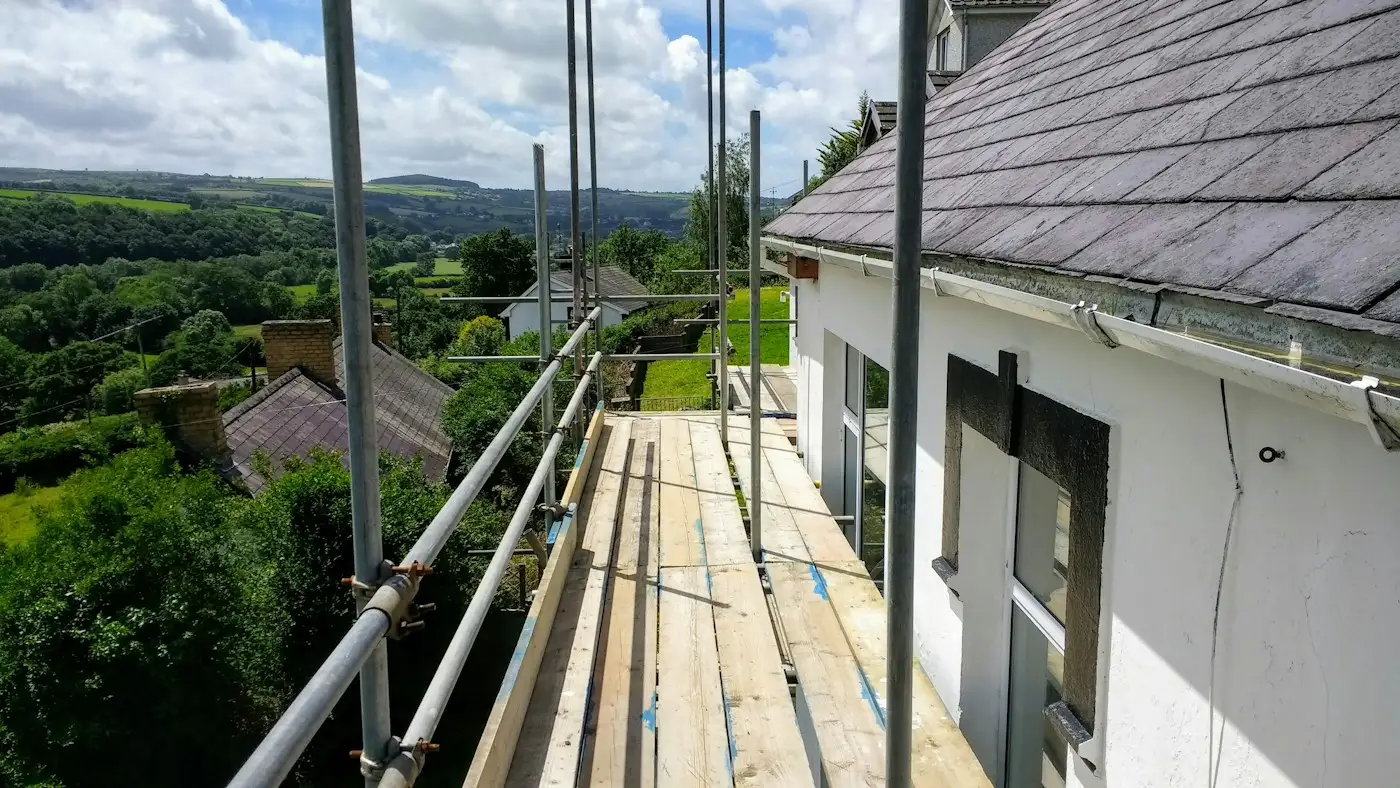 The view along the boards of a scaffold at the eaves of a house