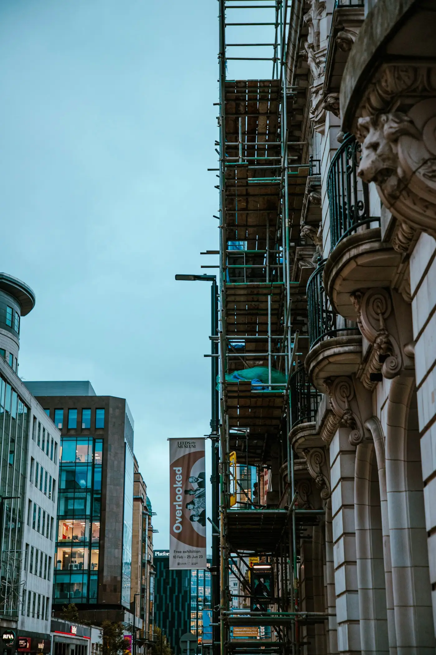 Scaffolding on an ornate stone building along a city street